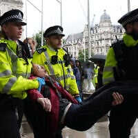 A protester is carried away by police officers at a demonstration in support of the proscribed group Palestine Action calling for the recently imposed ban to be lifted, in Parliament Square, central London, on July 19, 2025 (Carlos Jasso / AFP)