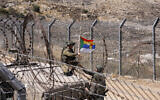 Israeli troops fix a Druze flag attached to the antenna of an army humvee at a position along the barbed-wire fence near the Druze village of Majdal Shams in the Golan Heights on July 19, 2025. (Jalaa MAREY / AFP)