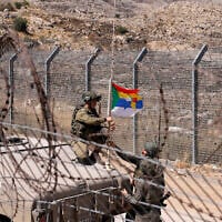 Israeli troops fix a Druze flag attached to the antenna of an army humvee at a position along the barbed-wire fence near the Druze village of Majdal Shams in the Golan Heights on July 19, 2025. (Jalaa MAREY / AFP)