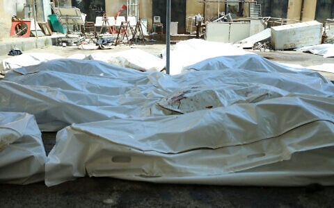 Unidentified bodies of people killed during sectarian violence the previous week lie in bags outside Sweida National Hospital in southern Syria's predominantly Druze city of Sweida on July 20, 2025. (Shadi Al-Dubaisi/AFP)