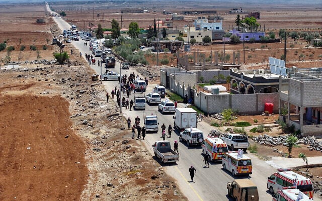An aerial picture shows a Syrian Red Crescent convoy carrying humanitarian aid driving across the southern town of Busra Al-Sham on July 20, 2025, heading to the predominantly Druze city of Sweida. (OMAR HAJ KADOUR / AFP)