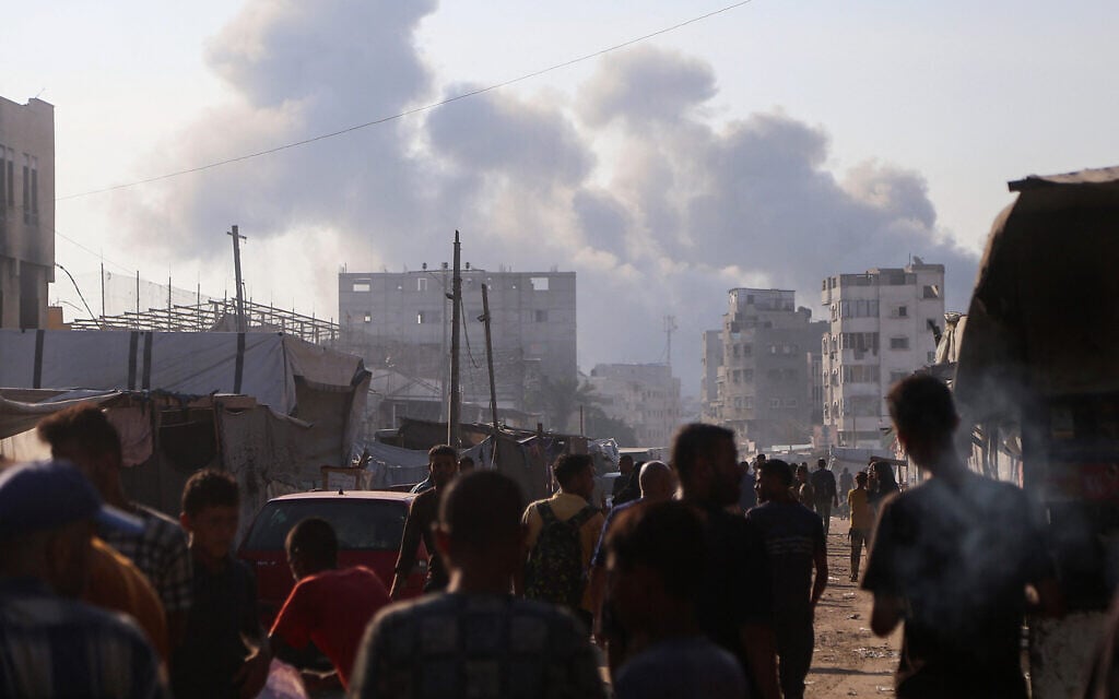 Palestinians look at smoke billowing amid Israeli strikes on central Khan Younis in the southern Gaza Strip on July 22, 2025. (AFP)