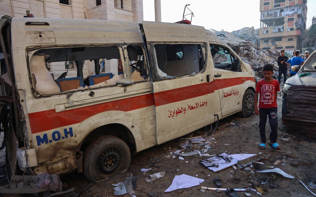 Palestinians inspect the damage, including a destroyed ambulance, around a house hit in an Israeli strike a day earlier in western Beit Lahia, in the northern Gaza Strip, on July 23, 2025. (Omar AL-QATTAA / AFP)