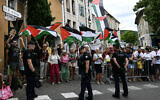 French gendarmes form a perimeter as onlookers wave Palestinian flags along the race route during the 17th stage of the 112th edition of the Tour de France cycling race, 160.4 km between Bollene and Valence, southern France, July 23, 2025. (Loic VENANCE / AFP)