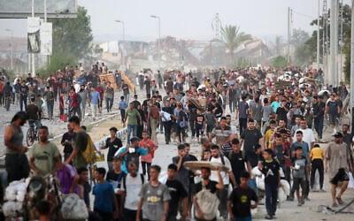 Palestinians make their way along al-Rashid street in western Jabalia on July 23, 2025, after receiving humanitarian aid from an aid distribution point in the northern Gaza Strip. (Eyad BABA / AFP)