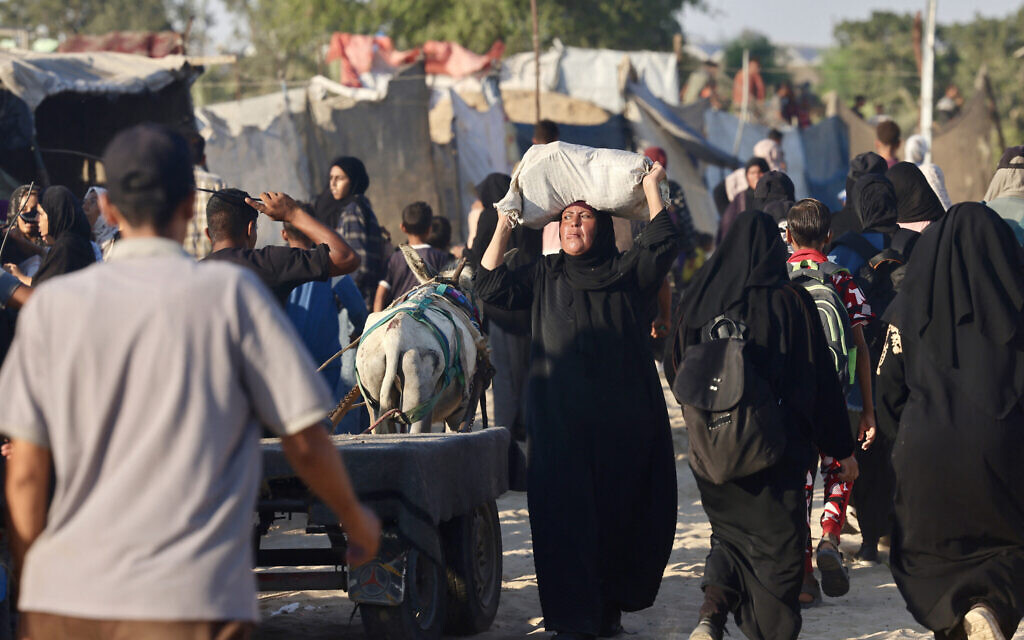 Palestinians make their way through the al-Mawasi area, near Rafah, on July 24, 2025, after receiving humanitarian aid from an aid distribution point in the southern Gaza Strip. (AFP)