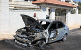 A man inspects a vehicle that was reportedly torched by settlers during an overnight attack on the West Bank Palestinian village of Taybeh, northeast of Ramallah, July 28, 2025. (Photo by Zain JAAFAR / AFP)