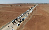 This handout picture released by the official Syrian Arab News Agency (SANA) on July 28, 2025, shows Syrian Red Crescent trucks carrying aid arriving at Busra al-Sham in Syria's southern Daraa province before crossing the buffer zone into Sweida province. (SANA/AFP)