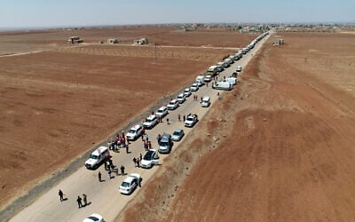 This handout picture released by the official Syrian Arab News Agency (SANA) on July 28, 2025, shows Syrian Red Crescent trucks carrying aid arriving at Busra al-Sham in Syria's southern Daraa province before crossing the buffer zone into Sweida province. (SANA/AFP)