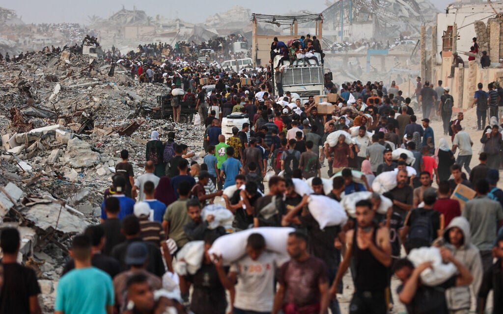 Gazans crowd a coastal path west of Beit Lahia after managing to get aid parcels on July 29, 2025. (Omar AL-QATTAA / AFP)