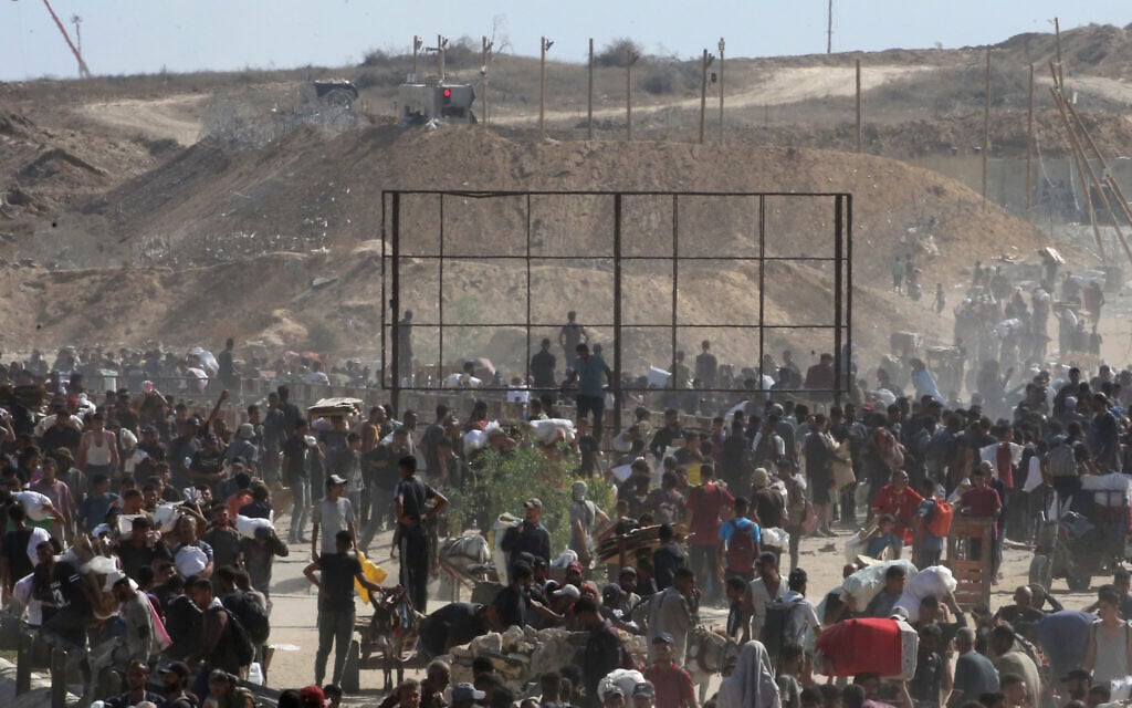 Displaced Palestinians gather to receive aid from a GHF aid distribution point in the so-called 'Netzarim corridor' area in the central Gaza Strip on July 30, 2025. (Eyad Baba/AFP)