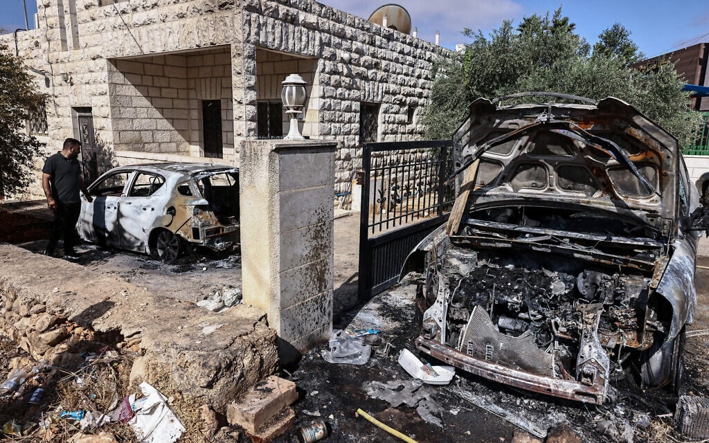 People inspect damage after an alleged attack by settlers in the West Bank town of Silwad on July 31, 2025. (Zain JAAFAR / AFP)