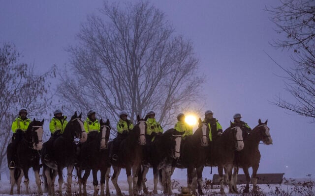 Canadian police officers on horseback watch as the motorcade for President Joe Biden and first lady Jill Biden arrive, Thursday, March 23, 2023, in Ottawa, Canada. (AP Photo/Andrew Harnik)