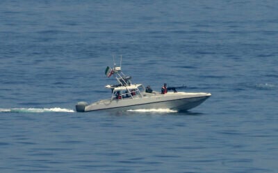 An Iranian Revolutionary Guard vessel watches an American warship in the Strait of Hormuz May 19, 2023. (Jon Gambrell/AP)