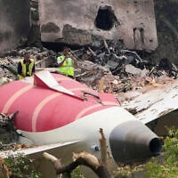 Officials inspect the site of an Air India plane crash that killed at least 260 people, on the roof of a building in Ahmedabad, India, June 13, 2025. (AP Photo/Ajit Solanki)