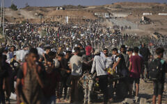 Palestinians carry humanitarian aid packages near the Gaza Humanitarian Foundation distribution center operated by the US-backed organization in Khan Younis, southern Gaza Strip, Thursday, June 26, 2025. (AP Photo/Abdel Kareem Hana)
