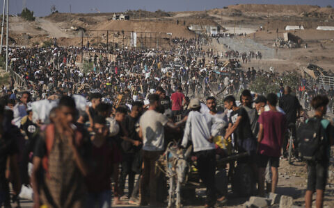 Palestinians carry humanitarian aid packages near the Gaza Humanitarian Foundation distribution center operated by the US-backed organization in Khan Younis, southern Gaza Strip, Thursday, June 26, 2025. (AP Photo/Abdel Kareem Hana)