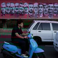 Vehicles drive past a banner showing portraits of the Iranian armed forces commanders and nuclear scientists who were killed in Israeli strikes, at Tajrish Square in northern Tehran, Iran, June 30, 2025. (AP/Vahid Salemi)