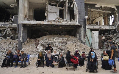Kidney patients sit amid rubble outside Shifa Hospital in Gaza City on Tuesday, July 1, 2025, as they wait to leave after the facility suspended its dialysis unit services due to fuel shortages needed to power its generators. (AP/Jehad Alshrafi)