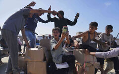 Palestinians carry boxes containing food and humanitarian aid packages delivered by the Gaza Humanitarian Foundation, in Rafah, southern Gaza Strip, May 27, 2025. (AP Photo/Abdel Kareem Hana)