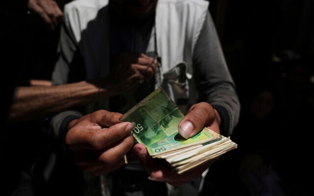 A Palestinian vegetable merchant shows worn-out Israeli currency, July 9, 2025, in Gaza City. (AP/Jehad Alshrafi) A Palestinian vegetable merchant shows worn-out Israeli currency, July 9, 2025, in Gaza City. (AP/Jehad Alshrafi)