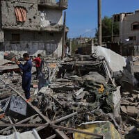 Palestinians inspect the wreckage of a gas station destroyed in an Israeli airstrike in Deir al-Balah, central Gaza Strip, July 12, 2025. (AP Photo/Abdel Kareem Hana)