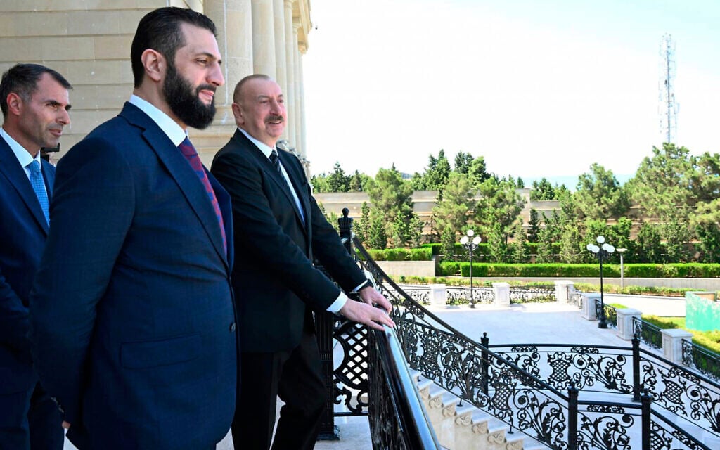 In this photo provided by Azerbaijan's Presidential Press Office, Azerbaijani President Ilham Aliyev, right, and Syria's interim president, Ahmad al-Sharaa, second left, stand on the balcony during their meeting in Baku, Azerbaijan, on July 12, 2025. (Azerbaijani Presidential Press Office via AP)