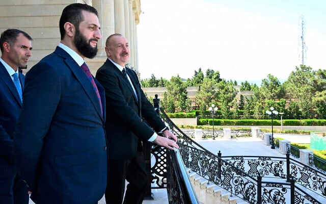 In this photo provided by Azerbaijan's Presidential Press Office, Azerbaijani President Ilham Aliyev, right, and Syria's interim president, Ahmad al-Sharaa, second left, stand on the balcony during their meeting in Baku, Azerbaijan, on July 12, 2025. (Azerbaijani Presidential Press Office via AP)