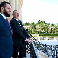 Azerbaijani President Ilham Aliyev, right, and Syria's interim president, Ahmad al-Sharaa, second left, stand on the balcony during their meeting in Baku, Azerbaijan, July 12, 2025. (Azerbaijani Presidential Press Office via AP)
