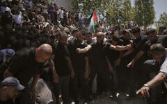 Mourners gather around the graves of Palestinian-American Saif Musallet, 20, and Mohammed al-Shalabi during their funeral in the West Bank village of Al-Mazraa ash-Sharqiya on Sunday, July 13, 2025. (AP/Leo Correa)