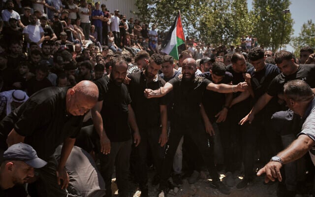 Mourners gather around the graves of Palestinian-American Saif Musallet, 20, and Mohammed al-Shalabi during their funeral in the West Bank village of Al-Mazraa ash-Sharqiya on Sunday, July 13, 2025. (AP/Leo Correa) Mourners gather around the graves of Palestinian-American Saif Musallet, 20, and Mohammed al-Shalabi during their funeral in the West Bank village of Al-Mazraa ash-Sharqiya on Sunday, July 13, 2025. (AP/Leo Correa)