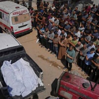 Mourners pray beside the bodies of Palestinians who were reportedly killed by an Israeli airstrike, during their funeral at Shifa Hospital in Gaza City, July 15, 2025. (AP Photo/Jehad Alshrafi)