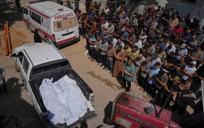 Mourners pray beside the bodies of Palestinians who were reportedly killed by an Israeli airstrike, during their funeral at Shifa Hospital in Gaza City, July 15, 2025. (AP Photo/Jehad Alshrafi)