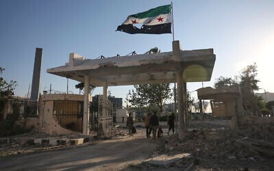 Security members carry belongings as they leave the damaged Syrian Defense Ministry building allegedly hit by several Israeli airstrikes, in Damascus, Syria, July 16, 2025. (AP Photo/Ghaith Alsayed)