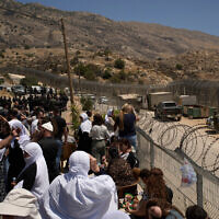 Members of the Israeli Druze community stand at the Israeli-Syrian border, in the town of Majdal Shams on Thursday, July 17, 2025. (AP/Leo Correa)
