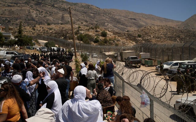 Members of the Israeli Druze community stand at the Israeli-Syrian border, in the town of Majdal Shams on Thursday, July 17, 2025. (AP/Leo Correa)