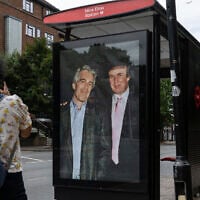 Commuters walk past a bus stop near Nine Elms Station as activists put up a poster showing US President Donald Trump and Jeffrey Epstein near the US Embassy in London, July 17, 2025. (AP Photo/Thomas Krych)