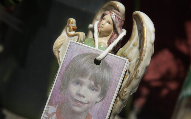 A photograph of Etan Patz hangs on an angel figurine, as part of a makeshift memorial in the SoHo neighborhood of New York, May 28, 2012. (AP Photo/ Mark Lennihan, File)