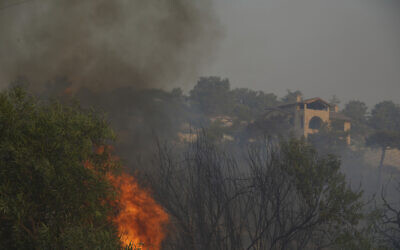 Flames burn near a house in Souni village, Cyprus, during a massive wildfire on the southern side of the east Mediterranean island nation's Troodos mountain range, July 24, 2025. (AP Photo/Petros Karadjias)