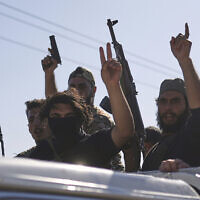 Bedouin fighters stand on a pickup truck as they arrive at al-Dour village on the outskirts of Sweida city, during clashes between the Bedouin clans and Druze militias, southern Syria, July 18, 2025. (AP Photo/Ghaith Alsayed)