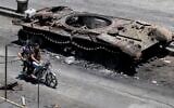 Druze militiamen ride a motorcycle past a destroyed military vehicle following last week's sectarian clashes in the Druze-majority town of Sweida, Syria, July 25, 2025. (AP Photo/Omar Sanadiki)