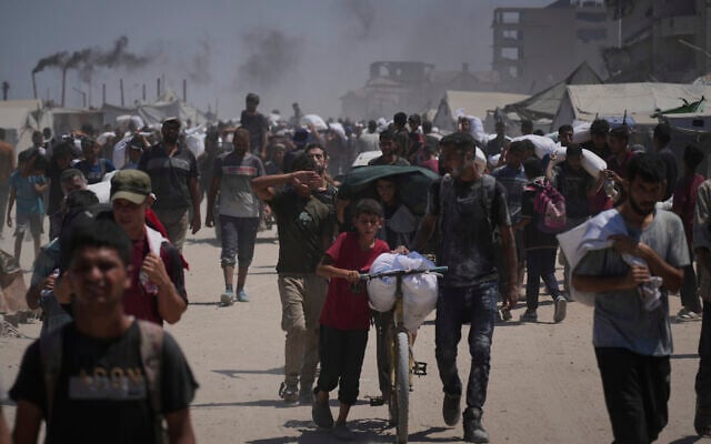 Illustrative: Palestinians carry sacks of flour unloaded from a humanitarian aid convoy that reached Gaza City from the northern Gaza Strip, Sunday, July 27, 2025. (AP Photo/Abdel Kareem Hana)