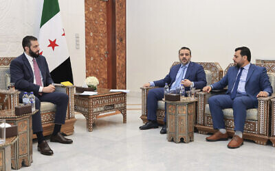 Syria's interim President Ahmad al-Sharaa, left, meets with Syria's Foreign Minister Asaad al-Shibani, center, and Mohammed Taha al-Ahmad, chairman of the Higher Committee for People's Assembly Elections, right, in Damascus, Syria, July 27, 2025. (Syria's official news agency, SANA via AP)