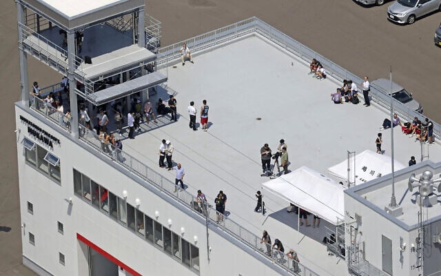People take shelter on the roof of a fire station in Mukawa town, Hokkaido, northern Japan, July 30, 2025, after a powerful earthquake in Russia's Far East prompted tsunami alert in parts of Japan. (Kyodo News via AP) People take shelter on the roof of a fire station in Mukawa town, Hokkaido, northern Japan, July 30, 2025, after a powerful earthquake in Russia's Far East prompted tsunami alert in parts of Japan. (Kyodo News via AP)