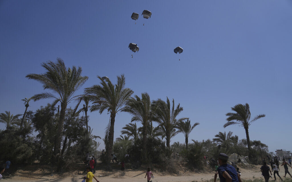 Palestinians rush to collect humanitarian aid airdropped into Zawaida in central Gaza Strip, Wednesday, July 30, 2025. (AP Photo/Abdel Kareem Hana)