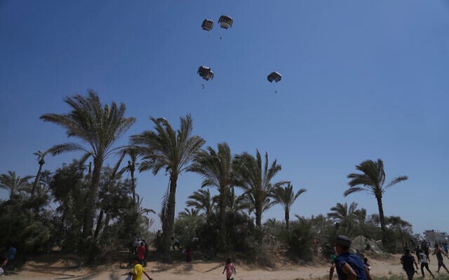 Palestinians rush to collect humanitarian aid airdropped into Zawaida in central Gaza Strip, Wednesday, July 30, 2025. (AP Photo/Abdel Kareem Hana)