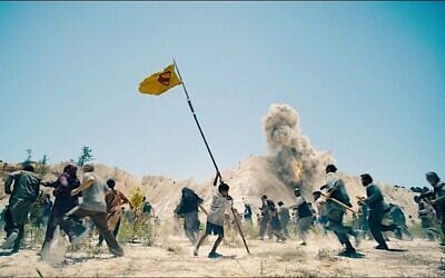 A child from the fictional country of Jahranpur waves a makeshift Superman flag during an attack by troops from the fictional country of Boravia, in 'Superman,' the 2025 film by James Gunn. (DC Studios/Warner Bros. via JTA)
