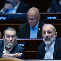 Shas chairman Aryeh Deri speaks with United Torah Judaism MK Moshe Gafni in the Knesset, December 14, 2023. (Yonatan Sindel/Flash90)