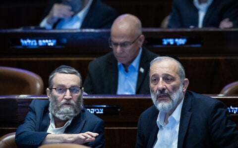 Shas chairman Aryeh Deri speaks with United Torah Judaism MK Moshe Gafni in the Knesset, December 14, 2023. (Yonatan Sindel/Flash90)