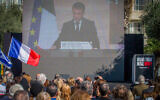 Israelis watch a screening of a ceremony attended by French President Emmanuel Macron in memory of the 42 French citizens who were murdered in the October 7 attack, at Hostages Square in Tel Aviv, February 7, 2024. (Flash90)